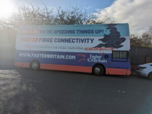 FasterBritain bus parked on the side of a road.